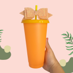Orange plastic cup with a yellow lid, straw and bow
