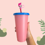 Pink plastic cup with a blue lid and straw