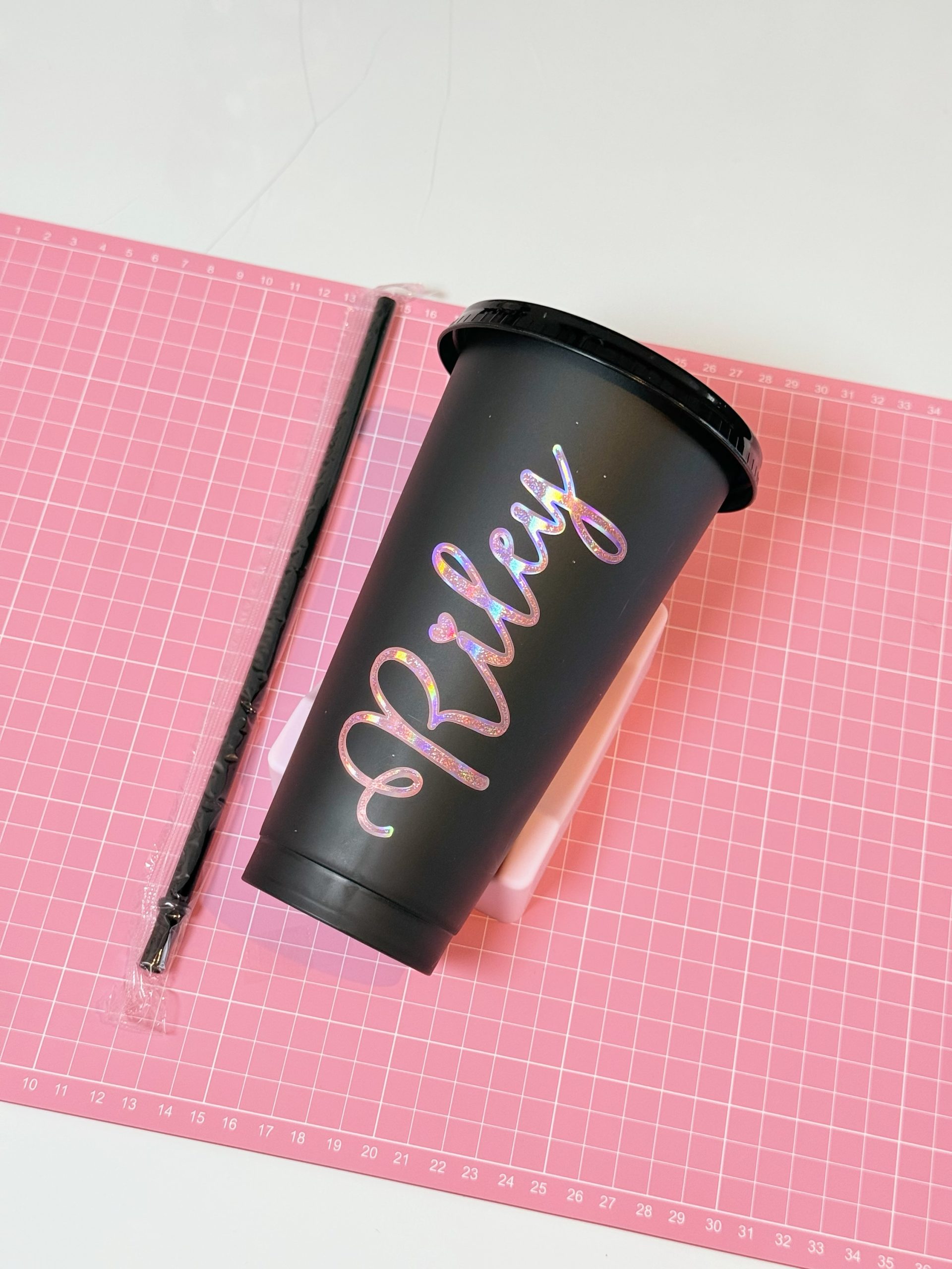 Black plastic cup with a personalized name, lid and straw