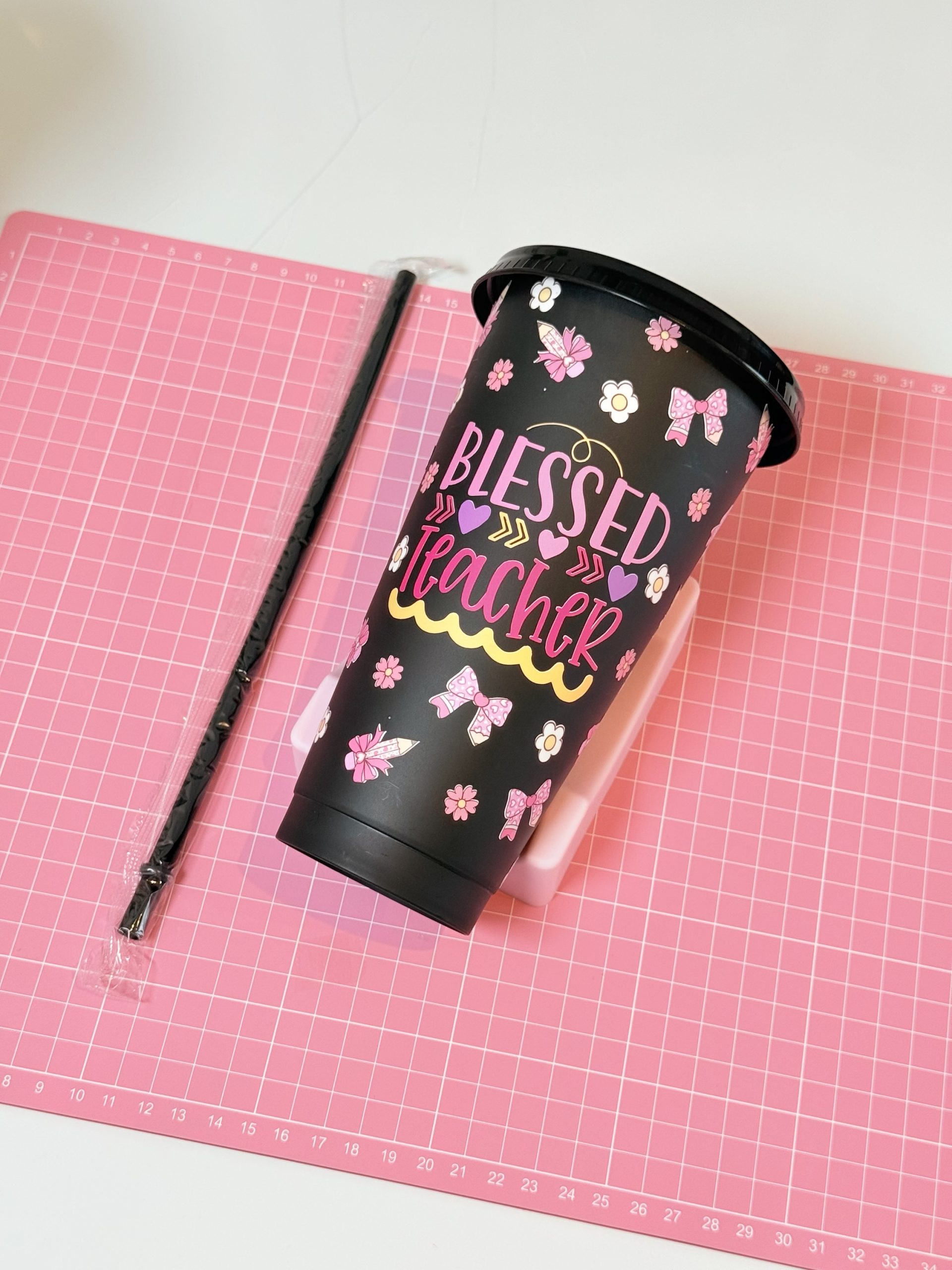 Black plastic cup with a personalized teacher design and straw