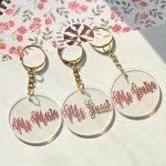Personalized round acrylic keychains with names and gold-colored rings