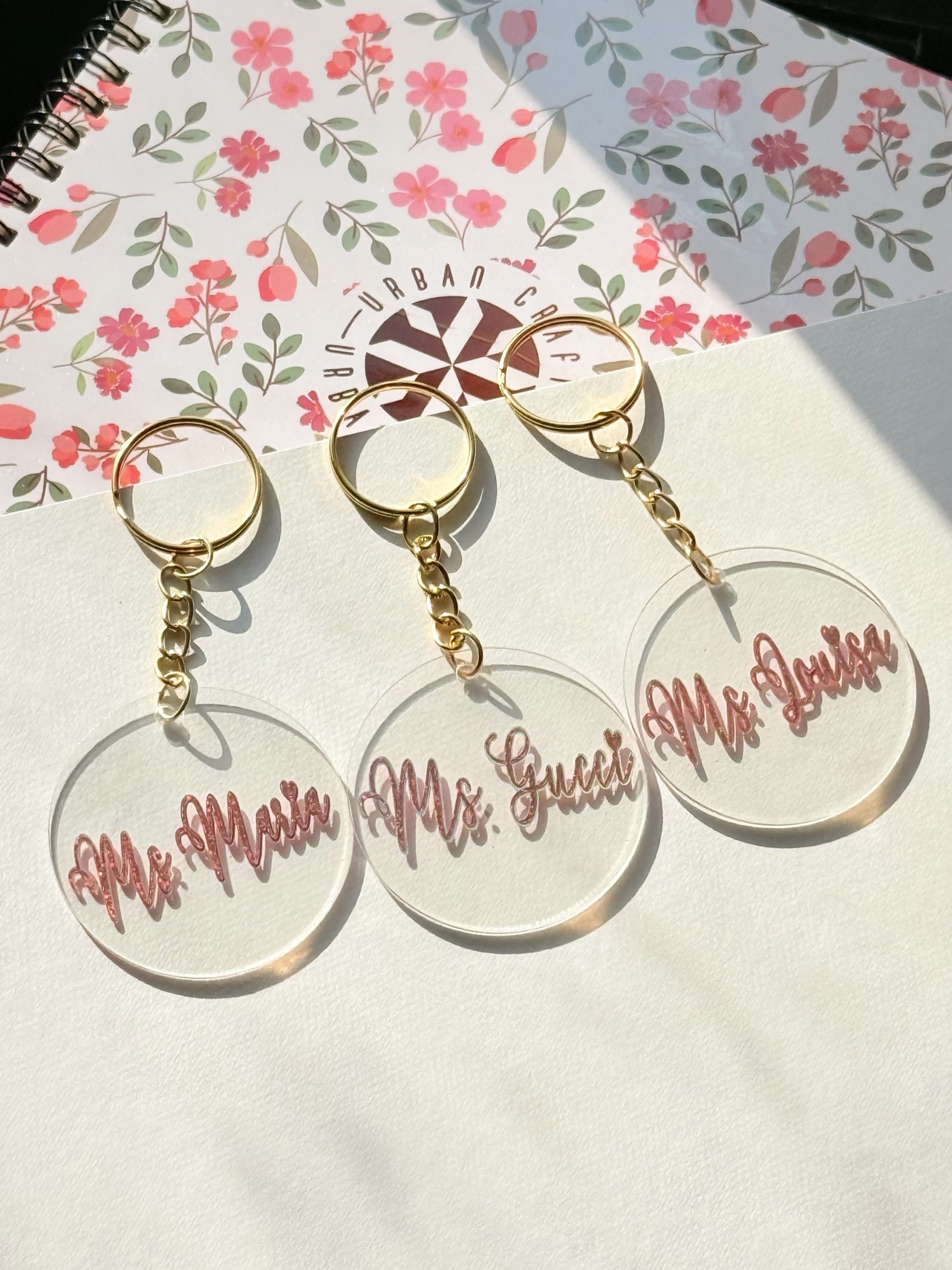 Personalized round acrylic keychains with names and gold-colored rings
