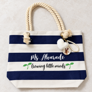 Actual navy and ivory rope-handle tote personalized for Ms. Alvarado with pearl loop, white fluffy heart and circular photo charm