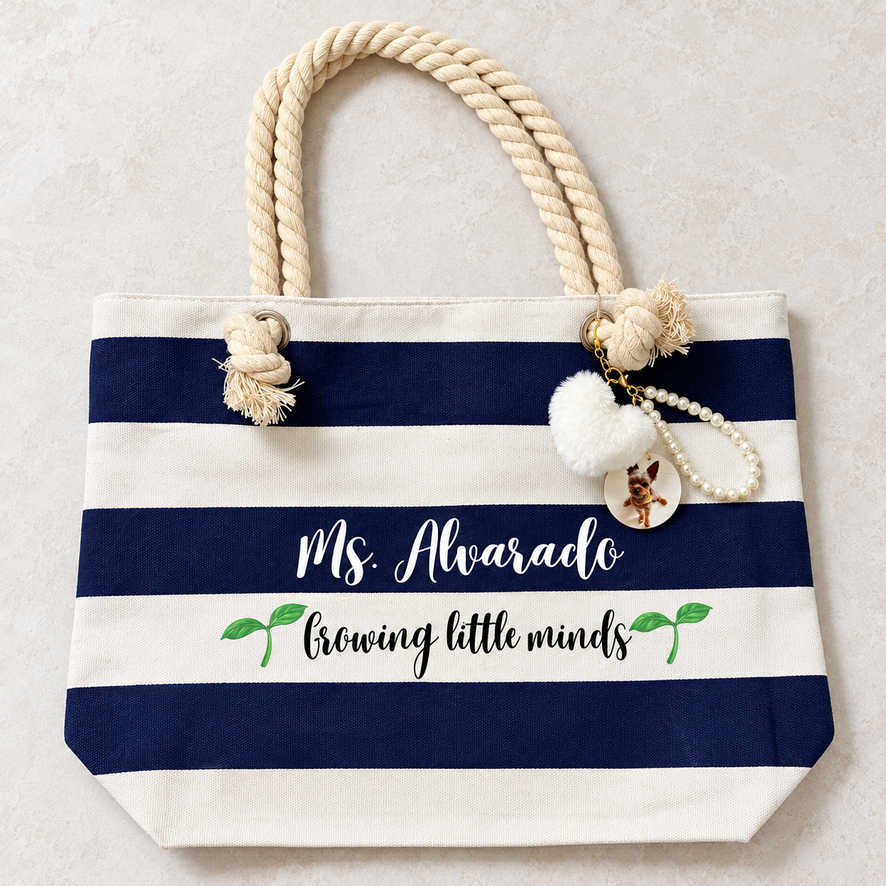 Actual navy and ivory rope-handle tote personalized for Ms. Alvarado with pearl loop, white fluffy heart and circular photo charm